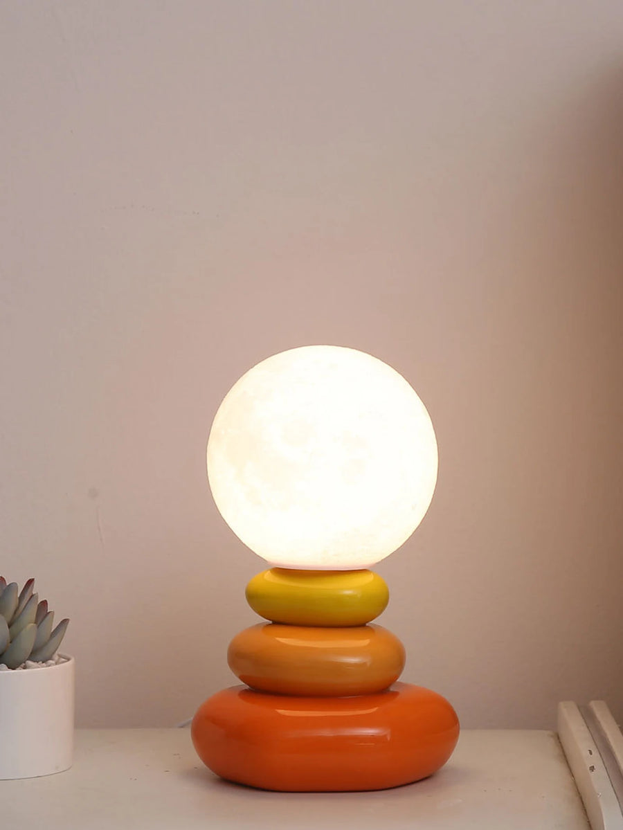 Orange Cielo stacked ceramic table lamp on a white desk