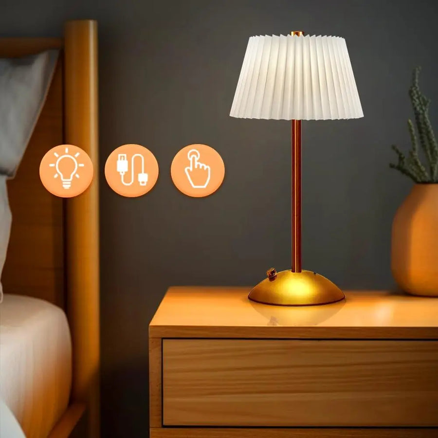 White Elara cordless pleated lamp glowing on a bedside table