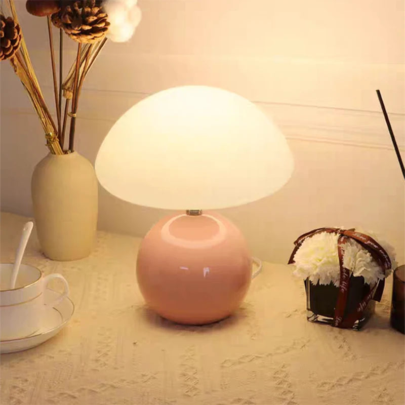 Pink Pola ceramic table lamp glowing on a dining table