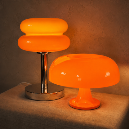 The Amber Pair close up: Oslo orange acrylic dome lamp in front of the Ambra amber glass dome lamp, both lit