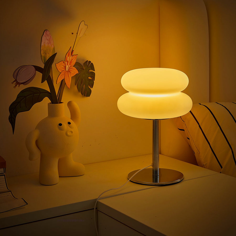 Halo tiered lamp glowing on a cream sideboard with flowers