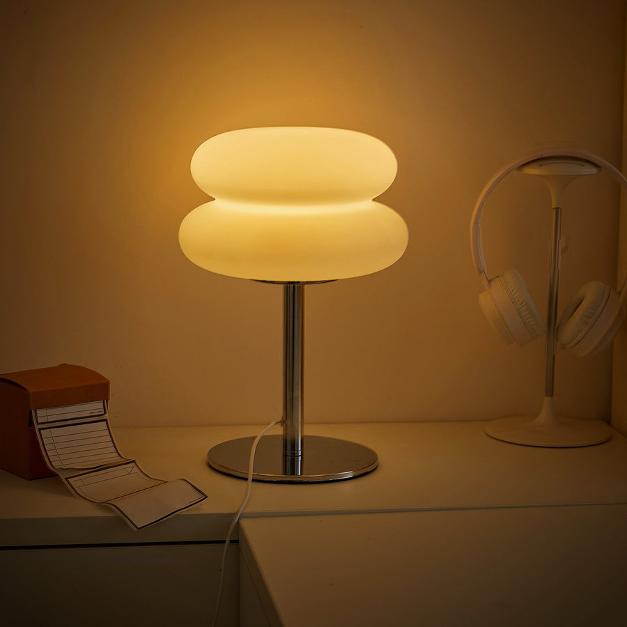 Halo lamp lit beside headphones on a desk