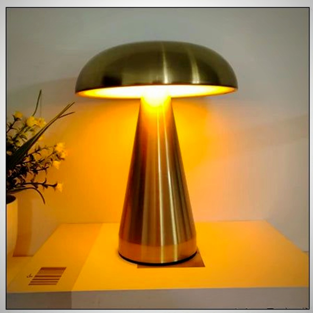 Juno gold mushroom table lamp lit on a table