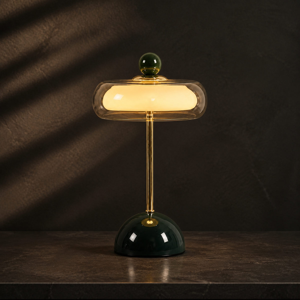 Dark green Oria rechargeable glass table lamp glowing on a dark wood surface