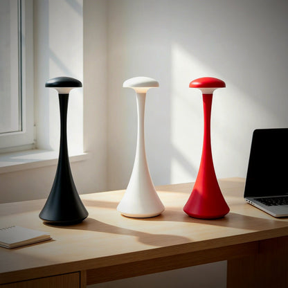 Pip slim mushroom lamps in black, white and orange on a desk