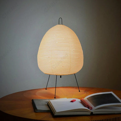 Lumae Yumi paper lantern lamp on a table with an open book